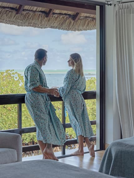 Couple in robes overlooking the Mauritius lagoon during a wellness stay